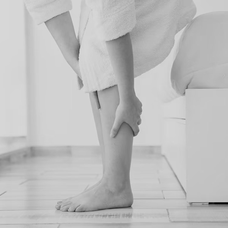 Woman massaging her leg, RLS symptoms